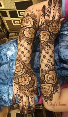 the hands and feet of a woman with henna tattoos on their arms, both covered in flowers