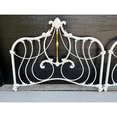 a white metal headboard with ornate designs