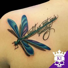 a dragonfly tattoo on the back of a woman's shoulder with words written in cursive writing