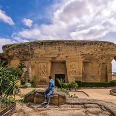 a man sitting on top of a rock formation