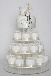 a tiered cake with white frosting and flowers on top