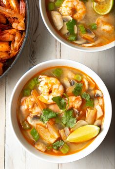 two bowls filled with shrimp and vegetable soup