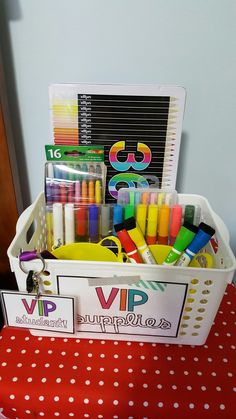 a white basket filled with markers and crayons on top of a red table