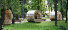 people are sitting on benches in the middle of an open area with trees and grass