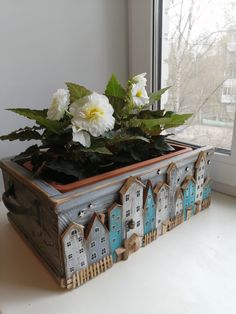 a wooden box with flowers in it sitting on a window sill