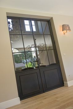 an empty room with a glass door and wooden floors in front of the window is a chandelier