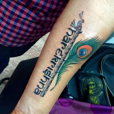 a person with a peacock feather tattoo on their arm