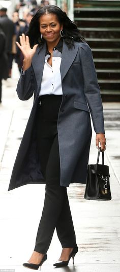 the first lady waves as she walks down the street