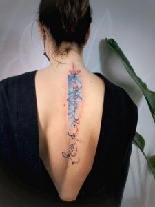 the back of a woman's neck with tattoos on it