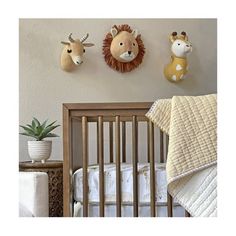 three stuffed animals mounted to the wall above a crib in a baby's room