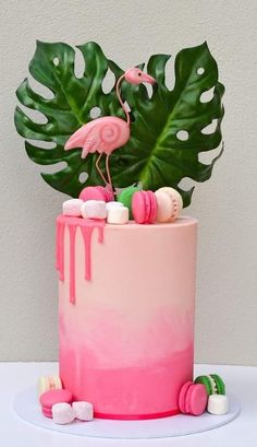 a cake decorated with pink icing, marshmallows and a flamingo