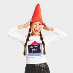 a woman wearing a red hat and black pants with her hands on her head while standing in front of a white background