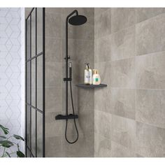 the shower head is shown with soap and shampoos on it, next to a tiled wall