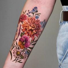 a woman's arm with flowers on it and a flower tattoo design on the left forearm