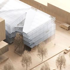 an aerial view of a building with trees in the foreground and people walking around