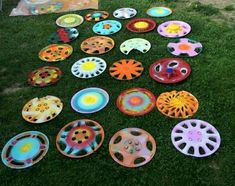 there are many different colored plates on the grass