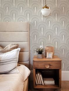 a bedroom with a bed, night stand and nightstand in front of a wallpapered wall