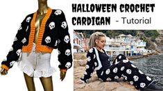 a woman sitting on top of a rock next to a body of water wearing a halloween crochet cardigan