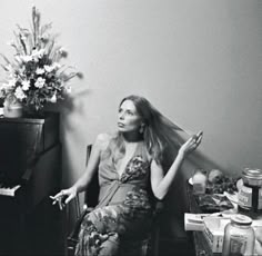 a woman sitting in a chair next to a piano with her hair blown back by the wind