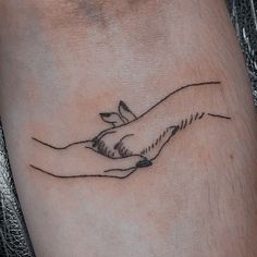 a tattoo on the arm of a person with a hand holding a bird in it