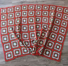 three red and white crocheted placemats sitting on top of a wooden floor