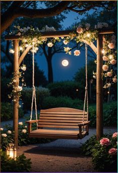 a wooden bench sitting under a tree covered in flowers and lit up with lights at night