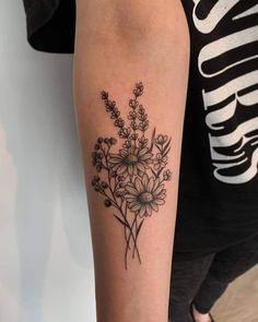 a black and white photo of a flower tattoo on the right arm with flowers in it