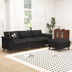 a black couch and ottoman in a living room with white rugs on the floor