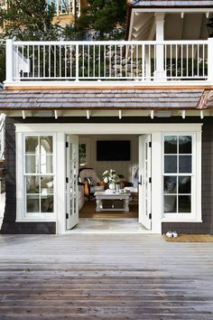 an outdoor living area with sliding glass doors and white railings on the outside wall