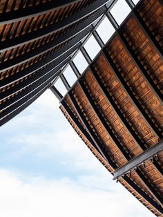 the underside of a building with wooden slats on it's sides and sky in the background