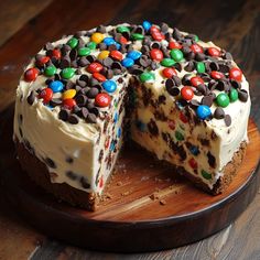 a cake with white frosting and multicolored candy toppings on the top