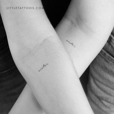 two people with matching tattoos on their arms, one is holding the other's arm