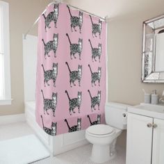 a pink shower curtain with black and white cats on it in a bathroom next to a toilet