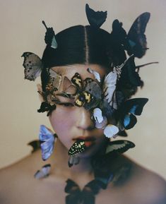 a woman with butterflies on her face and hair in front of her face is the image of an individual's head