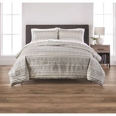 a bed in a room with wooden floors and white walls