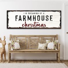 a wooden bench sitting in front of a white wall with the words farmhouse christmas on it