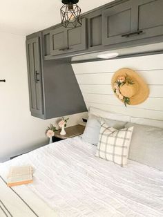 a bed with a hat on top of it next to a wall mounted book shelf