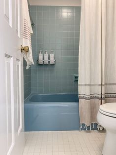 a white toilet sitting next to a bath tub in a bathroom