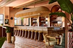 the interior of a restaurant with many chairs and bar stools in front of it