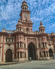 an old building with a clock on the top of it's tower and sky in the background