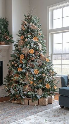 a living room with a christmas tree decorated in oranges and gold decorations on it