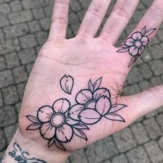 a person's hand with a flower tattoo on the middle of their left palm