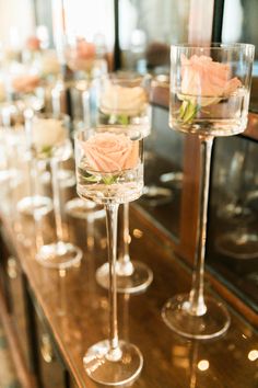 there are many wine glasses with flowers in them