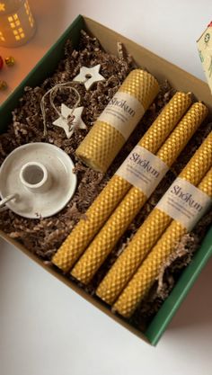 four yellow candles in a box on a table next to some decorations and other items