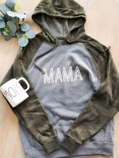 Mama grey and camo sleeved hoodie Adult sweatshirt 8 oz., 52/48 cotton/polyester blend, 32 singles Unisex, slim fit Reverse coverstitch sewing Twill neck tape 1 x 1 ribbing at neck, cuffs and waistband Sewn eyelets Self fabric side panel insert Camouflage Cotton Hoodie With Long Sleeves, Camouflage Long Sleeve Cotton Hoodie, Camouflage Cotton Hooded Sweatshirt, Casual Camouflage Cotton Hoodie, Camouflage Cotton Hoodie For Fall, Cotton Hooded Sweatshirt For Mother's Day, Camouflage Cotton Crew Neck Sweatshirt, Camouflage Cotton Long Sleeve Sweatshirt, Camouflage Cotton Sweatshirt For Winter