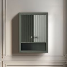 a wall mounted cabinet in the corner of a room with white walls and trimmings