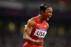 a woman running on a track with her mouth open