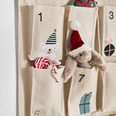 a stuffed animal in a pocket with numbers on it and a santa hat hanging from the wall