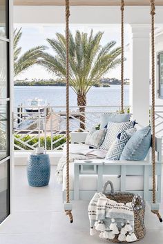 a porch swing with blue and white pillows