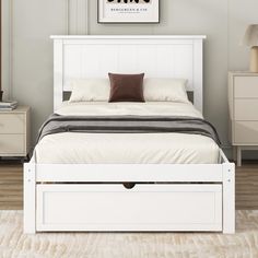 a white bed with two drawers underneath it